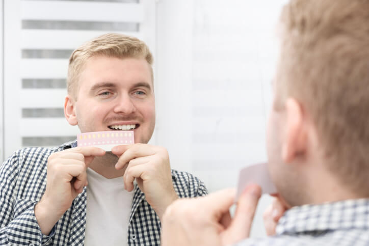 man checking teeth color with palette
